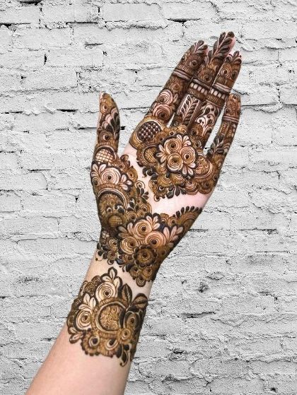 A dense and detailed floral pattern covering the back of the hand and wrist, perfect for someone who loves full, rich designs.