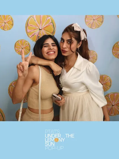 Two friends enjoying the sunny vibes at the PTAT pop-up. Our booth becomes a go-to spot for capturing the perfect social media picture.