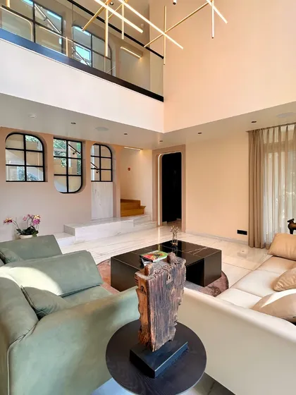 The double-height living room of our villa project at The Palm Springs, Gurugram. This space is designed to be the heart of the home, where generous volumes, warm lighting, and a connection to the upper floor create an environment of open, interactive family living.