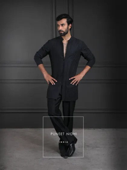 Black has always been the color of quiet power. This ensemble, detailed with geometric artistry and loop buttons, carries the aura of Indian regality, refined and unforgettable.
