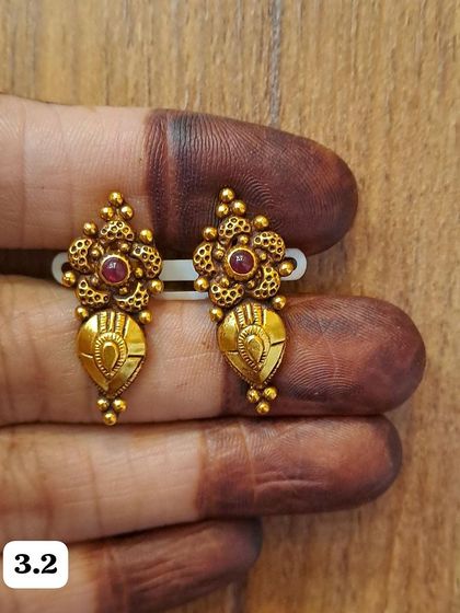 These small, antique gold-plated earrings feature a floral top and a teardrop-shaped bottom. They are lightweight and intricately detailed.