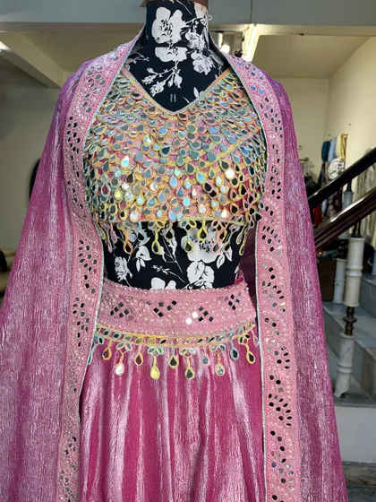 The lehenga comes with a matching dupatta with a mirror work border, completing the look perfectly.