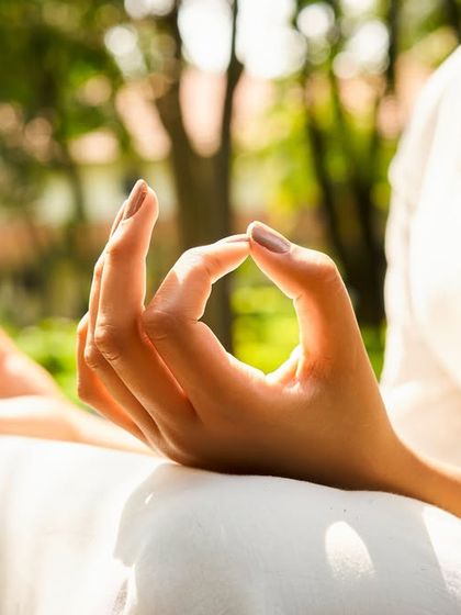 A close-up of hands in Gyan Mudra during meditation. This simple gesture helps improve concentration and connects you to your inner wisdom, a core part of the Ayurvedic lifestyle.