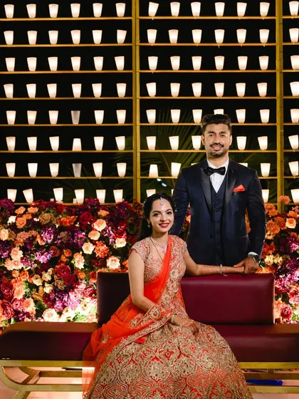 The couple shares a moment in front of the glowing candle wall. This unique backdrop provides warm, flattering light, perfect for romantic reception portraits.