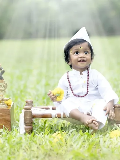 Looking up with a sweet expression, this little boy perfectly embodies the serene theme of his cultural photoshoot. These portraits are a unique way to celebrate your faith and traditions.