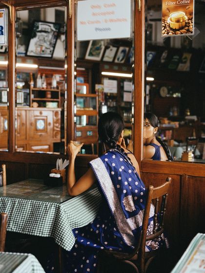 Another perspective from the Irani cafe scene, showing the reflection in the mirror. This adds a layer of depth and voyeurism to the visual story.