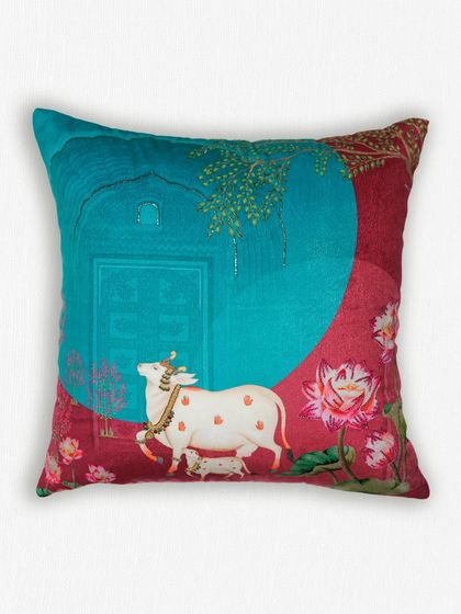 This cushion from our Pichwai collection features the sacred cow, or 'Kamdhenu', set against a beautifully detailed backdrop. The design is a modern interpretation of a classic art form, printed on luxurious fabric.