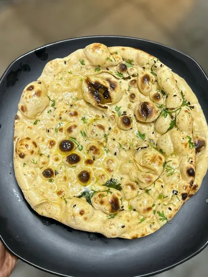 The perfect pairing: a hot, fluffy Butter Tandoori Roti. Made fresh in our tandoor, it's the ideal vessel for soaking up the delicious gravy of our Nihari or other curries.