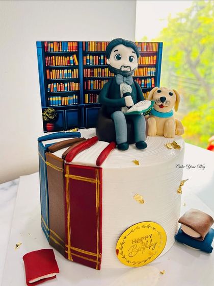 For the one who finds magic between pages and comfort beside a furry friend. A custom book-lover cake with a fondant figure and his dog.
