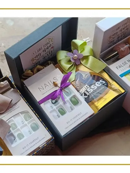 A closer look at our bridesmaid proposal boxes. These hampers include fun and useful items like press-on nails, chocolates, and satin scrunchies, with a card that asks, "I have my man, but I still need my girls!"