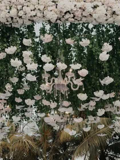 An intricate ceiling of hanging white flowers and crystal birds, creating a magical, dream-like canopy for the wedding ceremony.