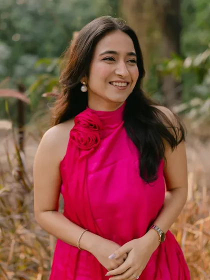 The complete look for a cocktail sundowner, featuring a vibrant pink dress. The soft makeup and simple hair create a look that is both elegant and relaxed.