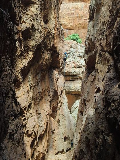 A climber navigates a narrow chimney route in Badami, a classic feature of the area. This demonstrates the variety of climbing styles covered in our advanced course.