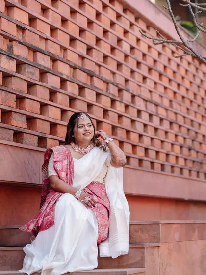 A stunning portrait of the bride, showcasing her elegant wedding look against a modern architectural backdrop.