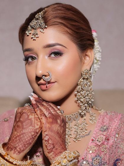 A close-up portrait of the bride, highlighting the flawless skin and soft pink makeup. The focus is on enhancing her natural features to create a look that is both beautiful and authentic.
