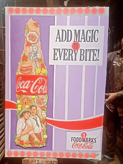 Holding up the large, hand-painted 'Add Magic to Every Bite' poster, ready for the event.