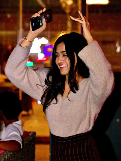 A guest dancing and capturing the moment on her phone.