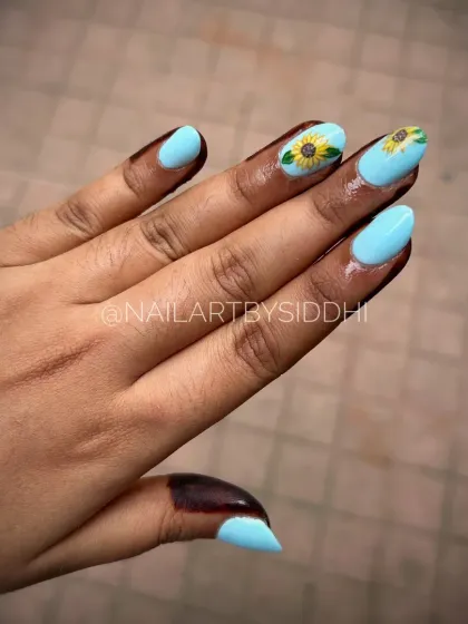 A cheerful design with a bright blue base and hand-painted sunflowers on the accent nails.