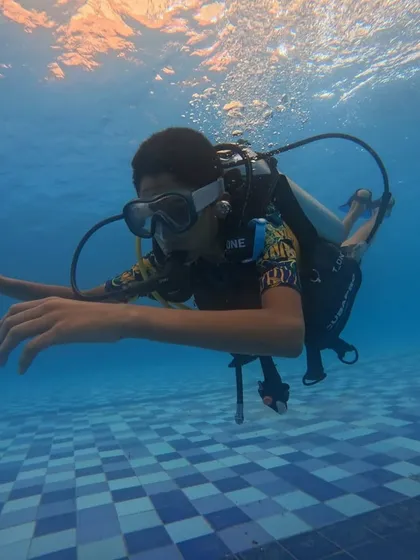 A participant experiences the unique sensation of breathing underwater during our introductory scuba diving session in Malpe. We conduct these initial lessons in the safety of a swimming pool to build confidence and teach essential skills.