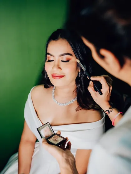 A moment of focus while applying eyeshadow. It's all about blending and building color to create the perfect shape and intensity for the bride's eyes.