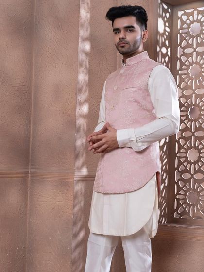 The rose pink bundi set, shown against a textured backdrop. The soft pastel tone is ideal for daytime celebrations and summer weddings, offering a sophisticated and stylish option.