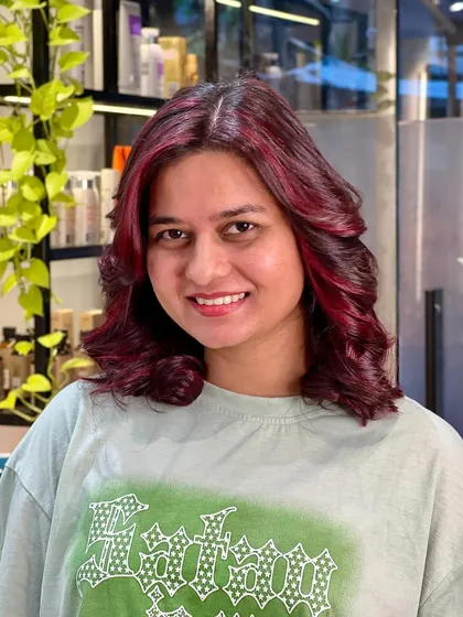 A beautiful red color with face-framing highlights. The client looks radiant and happy with her new look.