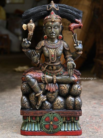 A unique 25.5-inch sculpture of Lord Mahadev (Shiva) seated on stones. The dark green antique finish gives this handcrafted piece a mystical and ancient feel, perfect for a pooja room.