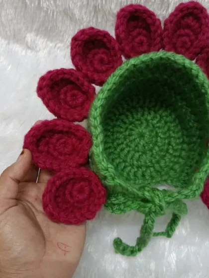 This is a flower bonnet I made for a photoshoot. The deep red petals stand out beautifully against the green cap, creating a stunning prop for baby photos.