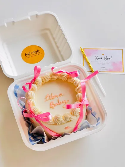 Another take on the "Libra Baby" theme, this time with an elegant piped border and delicate pink ribbons for a more decorative finish.