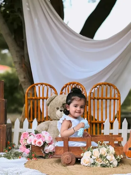 The birthday girl enjoying a ride in a little wooden wagon. Outdoor sessions allow for playful and interactive shots like this.