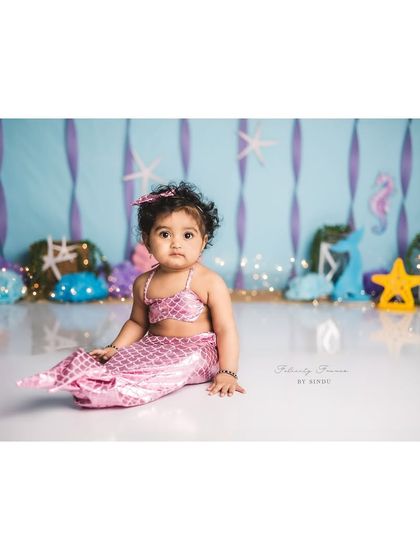 A classic portrait of our little mermaid, sitting gracefully on her white chair amidst her underwater treasures.