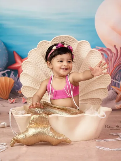 A whimsical and creative baby photoshoot featuring a little one as an adorable mermaid in a giant seashell. We love bringing imaginative themes to life for unique baby portraits.