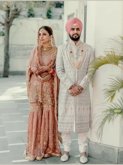 A formal portrait of the Sikh bride and groom, their coordinated pastel outfits reflecting a modern and sophisticated wedding style.