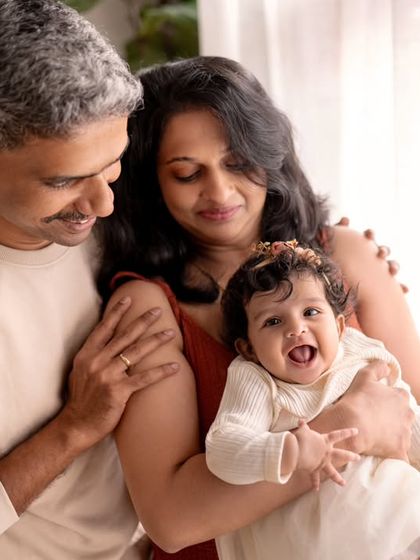A happy family of three, enjoying a moment together by the window. The laughter is contagious.