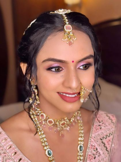 A close-up of the bride's face, highlighting the beautiful pink eyeshadow and glowing skin that gives her a fresh, youthful appearance.