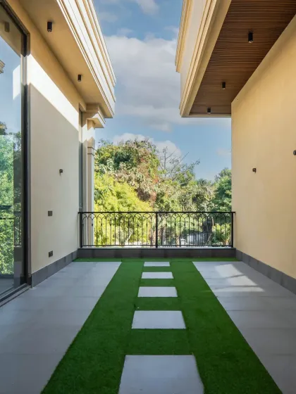 A simple yet elegant balcony design. The combination of artificial grass and clean white stone pavers creates a graphic, modern look that connects the indoor space with the outdoors.