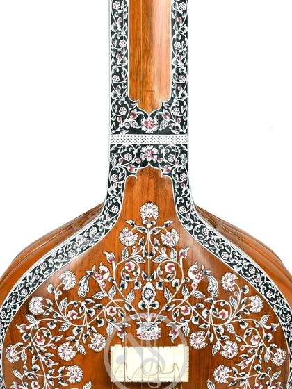 The back of the floral tanpura's body, showing the detailed inlay work that continues all around the instrument.
