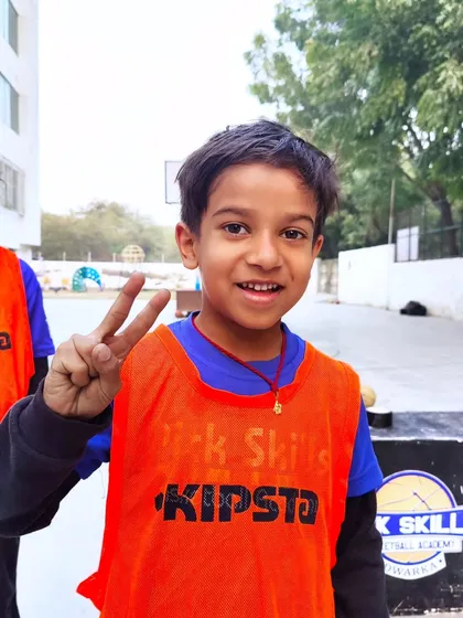 A happy player flashes a peace sign. Our goal is to build strong, confident individuals who grow both in the game and in life.