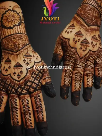 A closer look at a traditional bridal design featuring hanging jhumka motifs. The dense pattern work on the fingers and palm is a hallmark of classic Indian wedding mehndi.