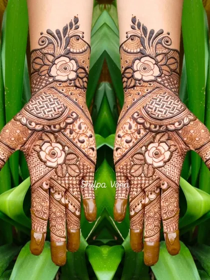 A beautiful floral design with roses, shown against a vibrant green background that makes the henna pop.