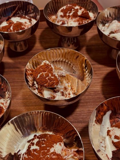 Individual servings of classic Tiramisu in elegant silver bowls. A sweet and authentic ending to a perfect Italian meal.