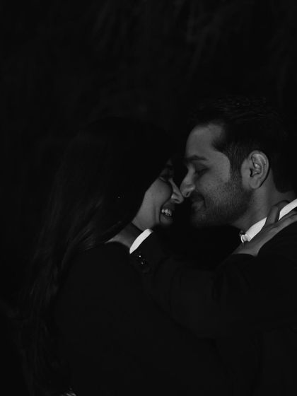 An intimate, low-light portrait. The focus is entirely on the couple's close connection, creating a romantic and moody photograph that feels very personal.