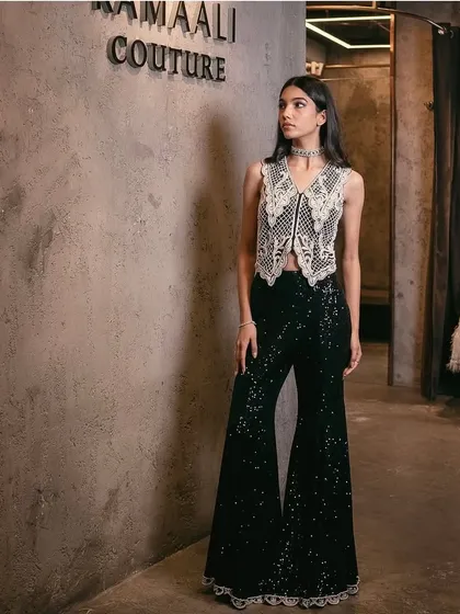 A festive ensemble featuring a waistcoat adorned with delicate pearl embroidery, complemented by fully sequin-embellished flared pants.