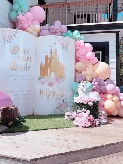 A fairytale comes to life with this 'Once Upon a Time' storybook backdrop. The giant open book, unicorn prop, and pastel balloon garland create a truly enchanting setting for a princess party.