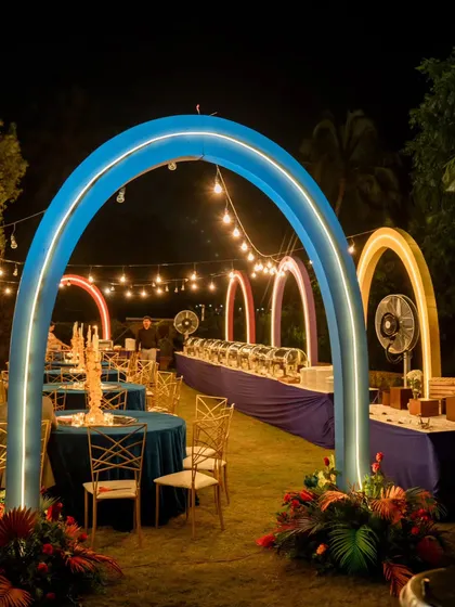 The dining area for our cosmic-themed sangeet. Glowing arches in blue, orange, and pink framed the buffet stations, creating a vibrant and futuristic dining experience under string lights.