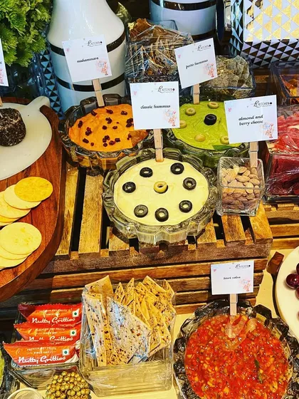 A wide view of the baby shower grazing table, showing the full assortment of dips, cheeses, crackers, and nuts, proving that even casual events can be elegant.