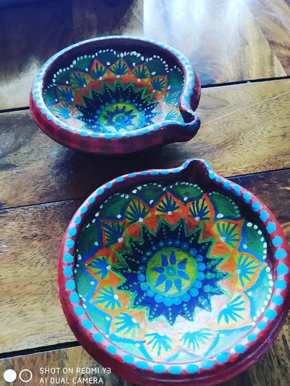 Here are two of my hand-painted terracotta diyas, perfect for Diwali. I use bright acrylic paints to create detailed mandala patterns, ensuring each piece is a unique work of art for your festive celebrations.