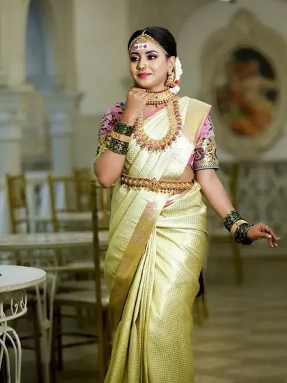 A bride in a simple yet elegant off-white saree, making our traditional temple jewellery the centerpiece of her look.