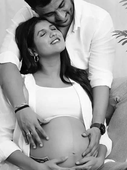 A beautiful black and white portrait focusing on the couple's hands on the baby bump, symbolizing their connection and shared love.