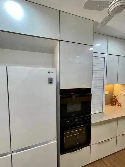 A built-in appliance unit in a straight laminate kitchen, seamlessly integrating the oven and microwave.